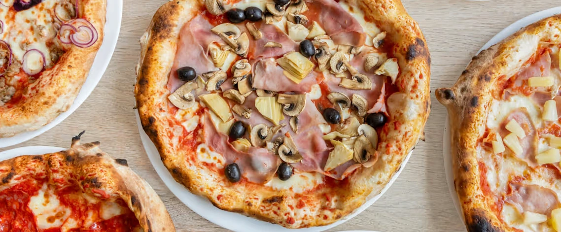 Frisch gebackene Pizza auf einem Holztisch in der Pizzeria